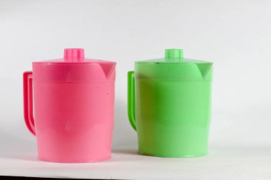 Pembe ve yeşil plastik su sürahisi harika ikili, retro mutfak titreşimleri veya renkli ürün modelleri ve eğlenceli, canlı yaz tasarımları için mükemmel..