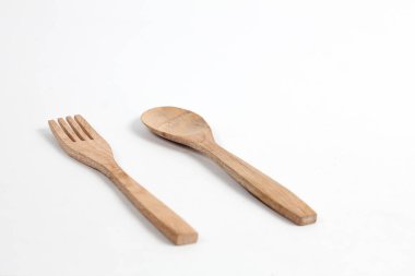 Tahtadan yapılmış kaşıklar ve çatallar beyaz arka planda izole edilmiş. Köy hissi veren geleneksel çatal bıçak takımı.