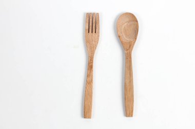 Tahtadan yapılmış kaşıklar ve çatallar beyaz arka planda izole edilmiş. Köy hissi veren geleneksel çatal bıçak takımı.