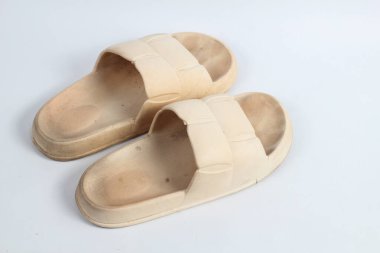 Beyaz arka planda izole edilmiş bir çift kirli lastik sandalet.