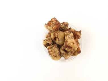 Beyaz arka planı olan şeffaf plastik bir kasede muzlu atıştırmalık yığını.