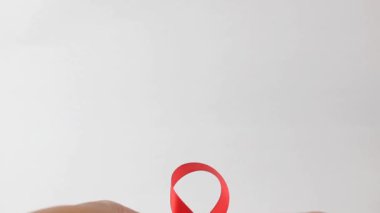 Aralık Dünya AIDS Günü için kırmızı kurdele gösteren eller, bağışıklık yetmezliği sendromu, çoklu miyelom kanseri farkındalığı ayı ve Ulusal Kırmızı Kurdele Haftası. Sağlık ve Dünya Kanseri