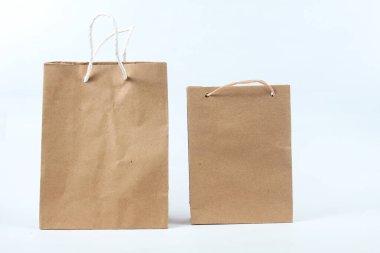 Beyaz arkaplanda geniş ve küçük alışveriş çantaları var.