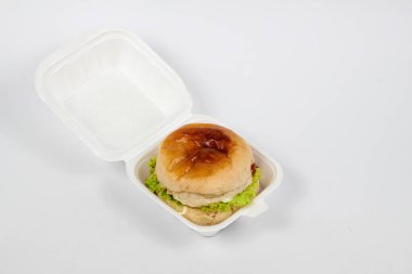 Beyaz arka planda izole edilmiş köpük kabında lezzetli bir hamburger.