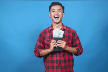 Heyecanlı Genç Adam Mutlulukla Tasarruf kitaplarından toplanmış Amerikan Doları Faturalarını Sergiliyor