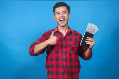 Mutlu genç adam içinde biraz para olan bir tasarruf kitabı tutuyor ve finansal başarı ve mutluluğun ifadesi olarak onaylıyor..