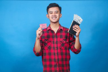 Asyalı adam elinde dolar ve kredi kartı içeren bir kitap tutuyor. Neşeli bir ifadeyle bonus alıyor.