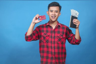 Asyalı adam elinde dolar ve kredi kartı içeren bir kitap tutuyor. Neşeli bir ifadeyle bonus alıyor.