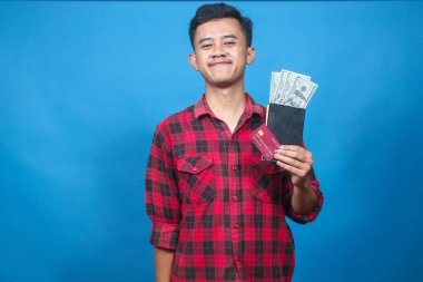Asyalı adam elinde dolar ve kredi kartı içeren bir kitap tutuyor. Neşeli bir ifadeyle bonus alıyor.