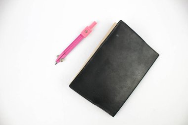 okul pusulası ve beyaz arkaplanda izole edilmiş küçük kitap