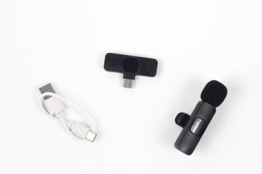 Adaptör, kablosuz mikrofon ve beyaz arkaplanda izole edilmiş şarj edilebilir kablo