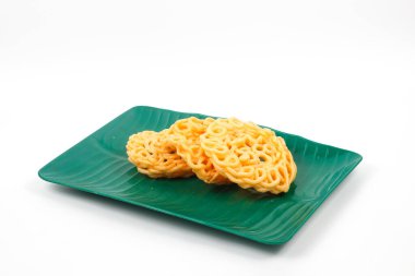 Beyaz arka planda izole edilmiş yeşil plastik tepside atıştırmalıklar ve geleneksel çıtır krakerler (kerupuk)