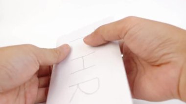 para içeren bir THR (tatil harçlığı) zarfı açmak ve onu beyaz bir arkaplanda izole edilmiş kameraya göstermek