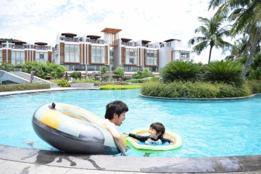 Baba ve oğul yaz havuzda oynarken