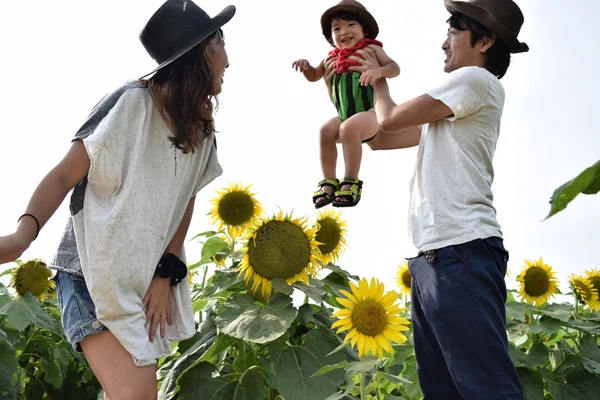 Молода сім'я посміхається з соняшниковим полем — стокове фото