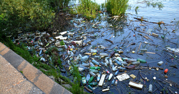 Загрязненная река с различным мусором и мусором
