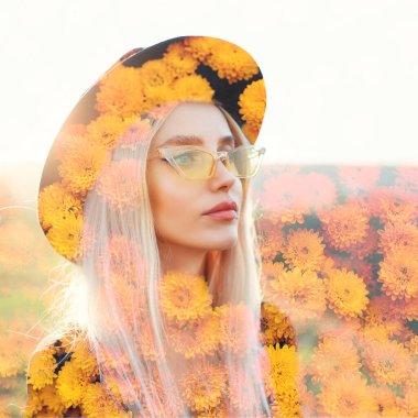 Çifte maruz kalma etkisi. Gözlüklü ve siyah şapkalı genç bir kızın portresi. Sarı kasımpatı çiçeklerinin arka planı.