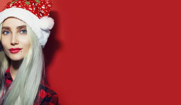Kırmızı Arka Planda Noel Baba Şapkası Takan Genç Sarışın Kızın — Stok fotoğraf