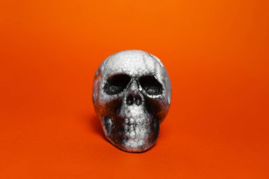 Turuncu ya da yemyeşil lav rengi arka planda anatomik insan ürkütücü kafatasının yakın çekimi.