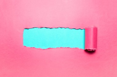 Cyan arkaplan metni için boşluğu olan çapraz yırtılmış pembe kağıt.