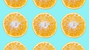 Hareket fotoğrafçılığını bırak. Cyan renginin arka planında kesilmiş portakal meyvelerinin renkli deseni.