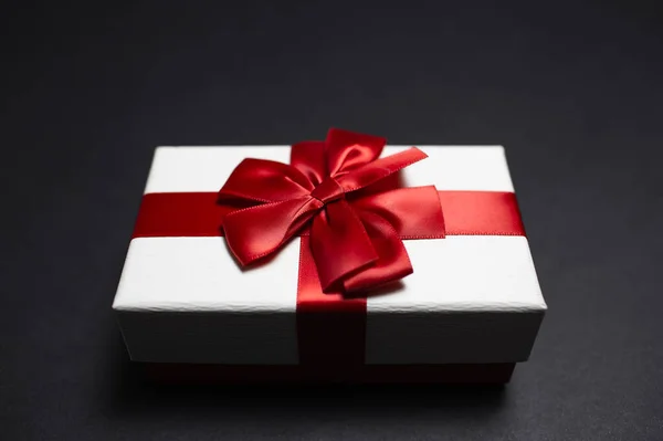 Close Caixa Presente Branco Com Laço Fita Vermelha Fundo Preto — Fotografia de Stock