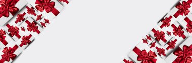 Beyaz arkaplanda izole edilmiş kırmızı yaylı hediye kutularının panoramik fotoğrafı.