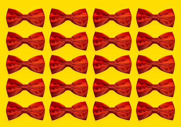 Pattern of red bow ties isolated on yellow background.