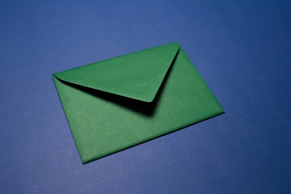 Крупный План Бумажного Конверта Зеленого Цвета Изолирован Фоне Текстурированной Синей — стоковое фото