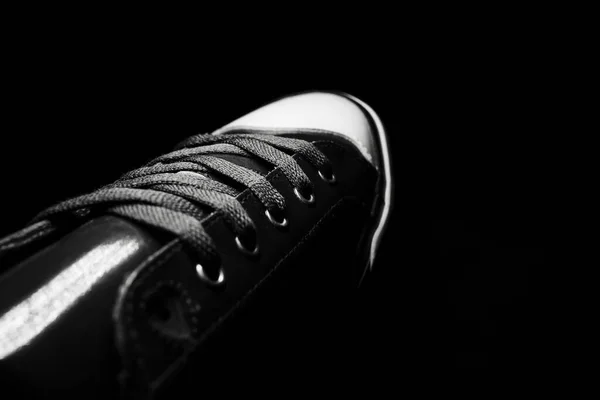 Old school fashion sport shoe. Close-up of vintage sneakers. Black and white photo.