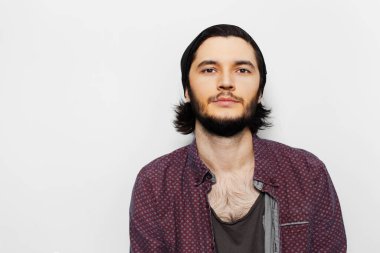 Beyaz arka planda kendine güvenen genç adamın stüdyo portresi.