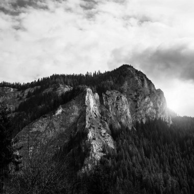 Dağların zirvesinden oluşan karanlık bir manzara. Siyah beyaz fotoğraf.