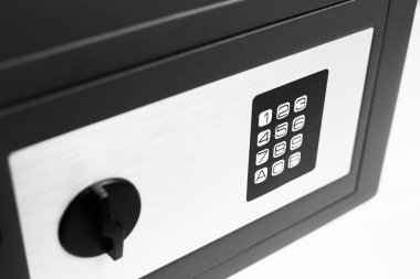 Beyaz arka plandaki güvenlik kasasına yakın plan. Siyah beyaz fotoğraf.