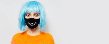 Siyah tıbbi maske takan genç bir kızın portresi beyaz stüdyo arka planında koronavirüse karşı fotokopi alanı ile.