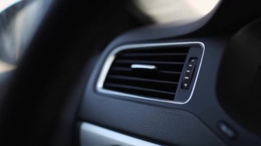 Arabadaki klima veya iklim kontrolünden erkek elinin hava akımını açtığı yakın plan.