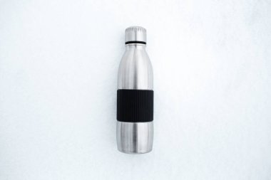 Kar üzerinde yeniden kullanılabilir çelik termo su şişesinin üst görüntüsü.