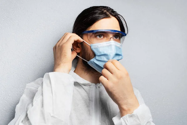 Porträtt Ung Läkare Man Bär Ppe Kostym Sätta Medicinsk Ansiktsmask — Stockfoto