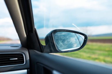 Otomobil aracının içinden arabanın yan aynasının yakın görüntüsü.