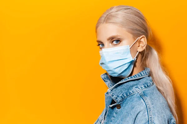 Side Studio Porträtt Ung Blond Flicka Bär Medicinsk Ansiktsmask Mot — Stockfoto