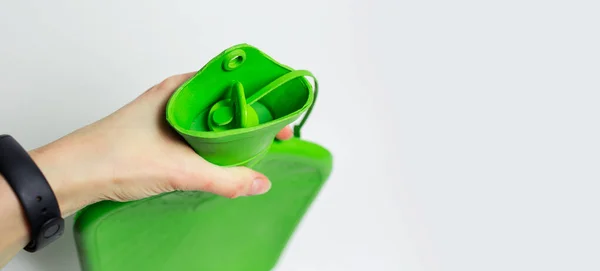 Närbild Kvinnlig Hand Håller Grön Medicinsk Varmvattenflaska Och Mössa Isolerad — Stockfoto