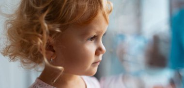 Pencereden bakan düşünceli bir kızın yan portresi..