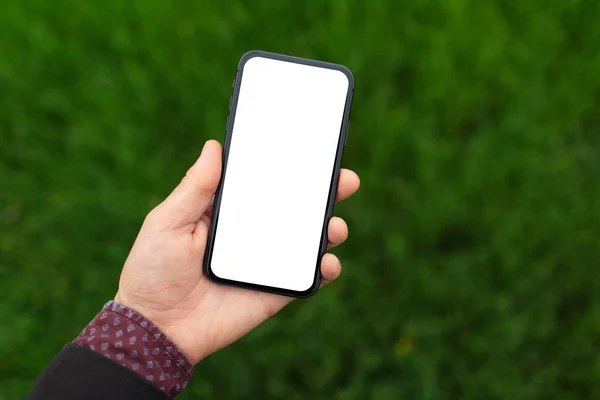 Close Male Hand Holding Smartphone Mockup Background Blurred Green Grass — Stock Photo, Image