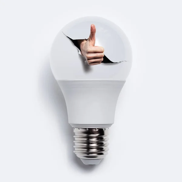 Close Hand Showing Thumbs Gesture Torn Hole Light Bulb White — Stock Photo, Image