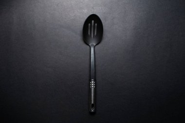 Krom saplı büyük siyah plastik kaşık stüdyo resmi.