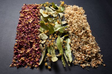 Stüdyo fotoğrafçılığı. Sıraya dizilmiş kurutulmuş otlar. Karanlık masa üzerinde..