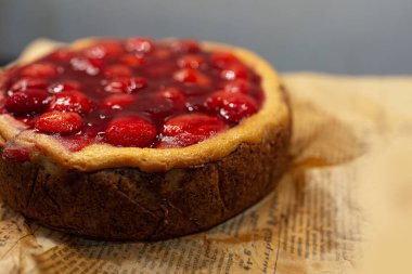 Eski gazetede çilekli turtanın yakın plan görüntüsü.