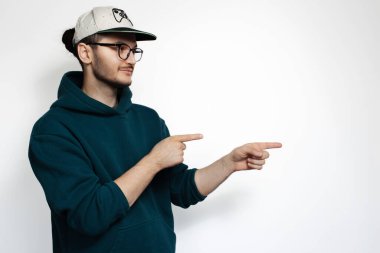 Boş alanda işaret parmağı gösteren genç bir adamın portresi.