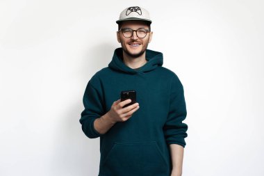 Elinde akıllı telefonla gülümseyen genç adam. Beyaz arkaplanda izole.