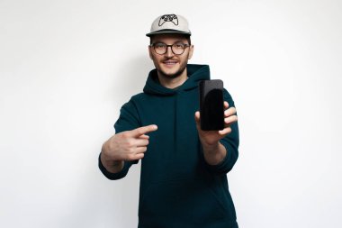 Gülümseyen genç işaret parmağı akıllı telefonda, beyaz arka planda izole edilmiş..