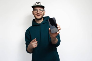 Mutlu genç adam işaret parmağı akıllı telefonda, beyaz arka planda izole edilmiş..